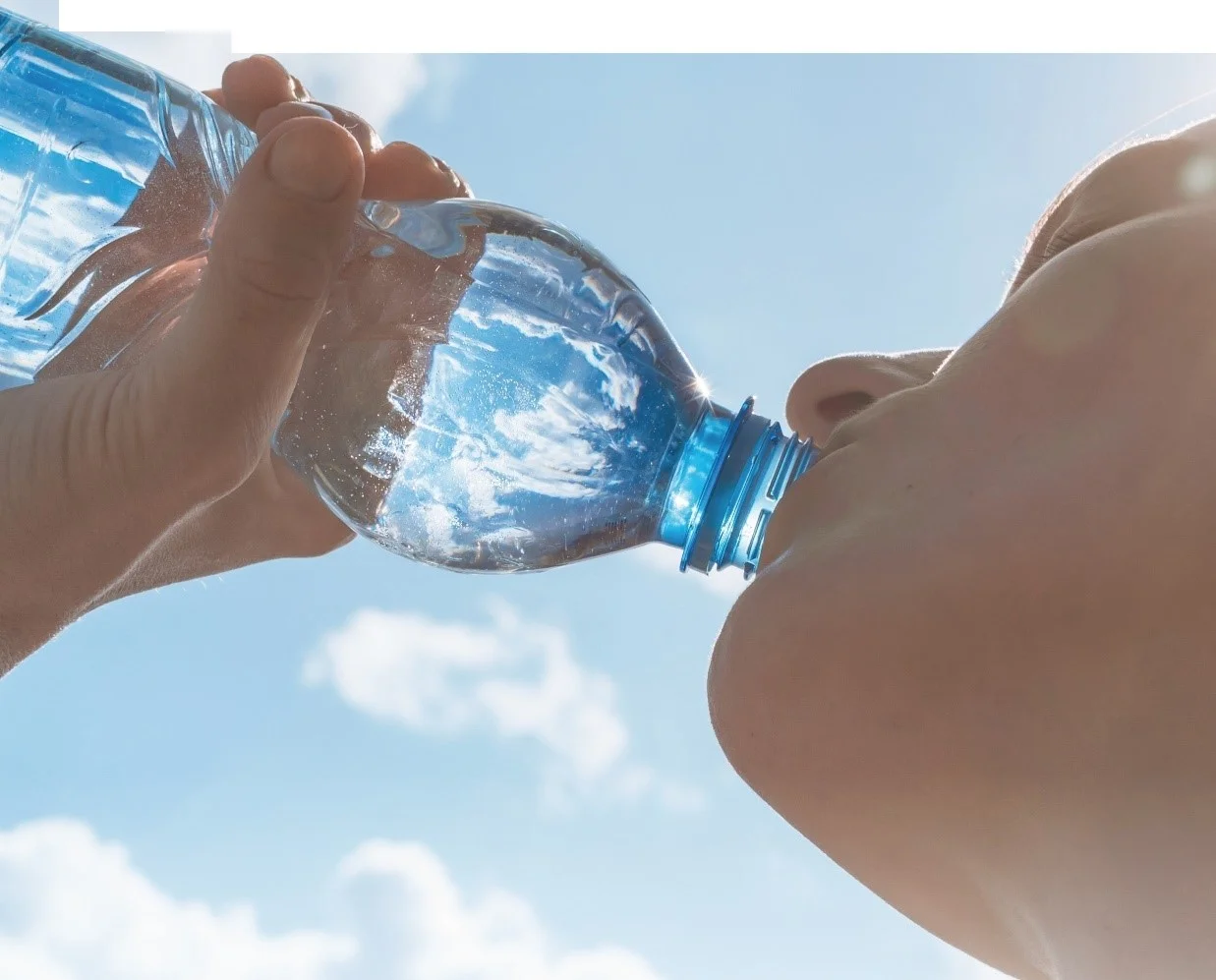 透明なボトル入りの水を持つ一対の手