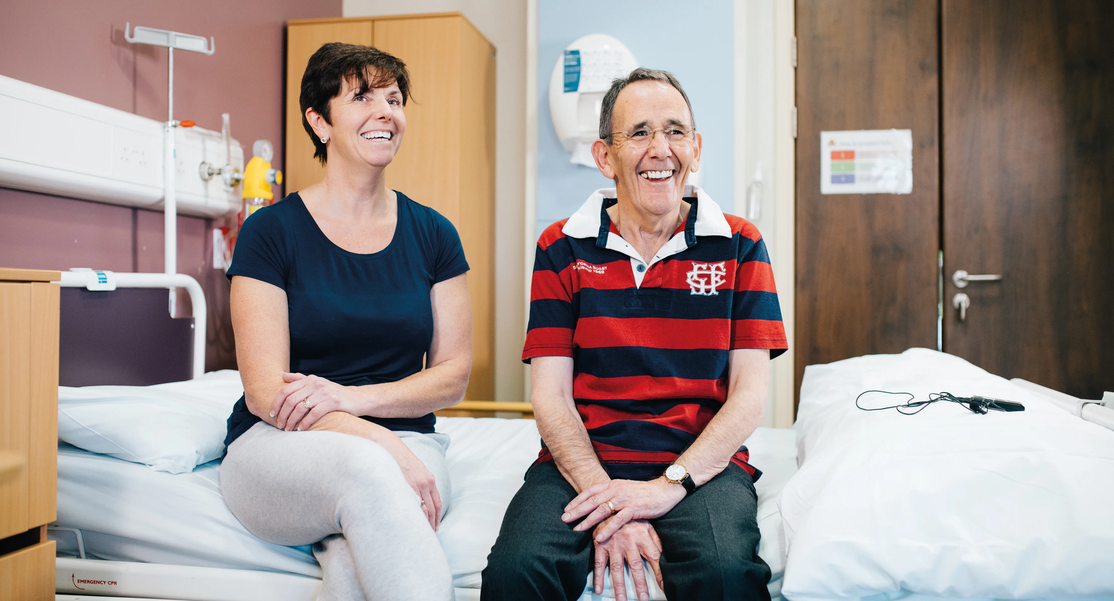 a man and a woman sitting on a bed