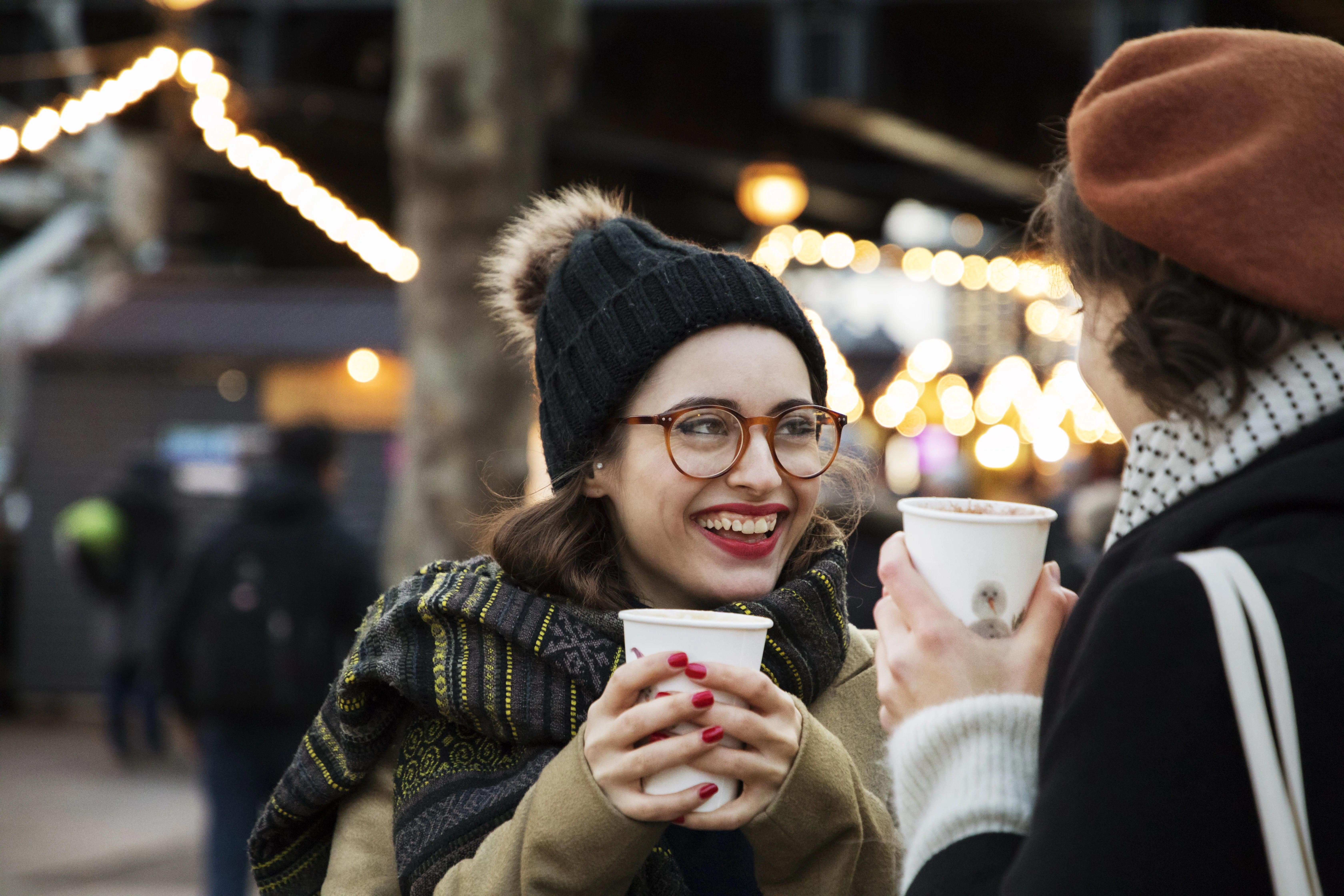a person holding a cup and a cell phone