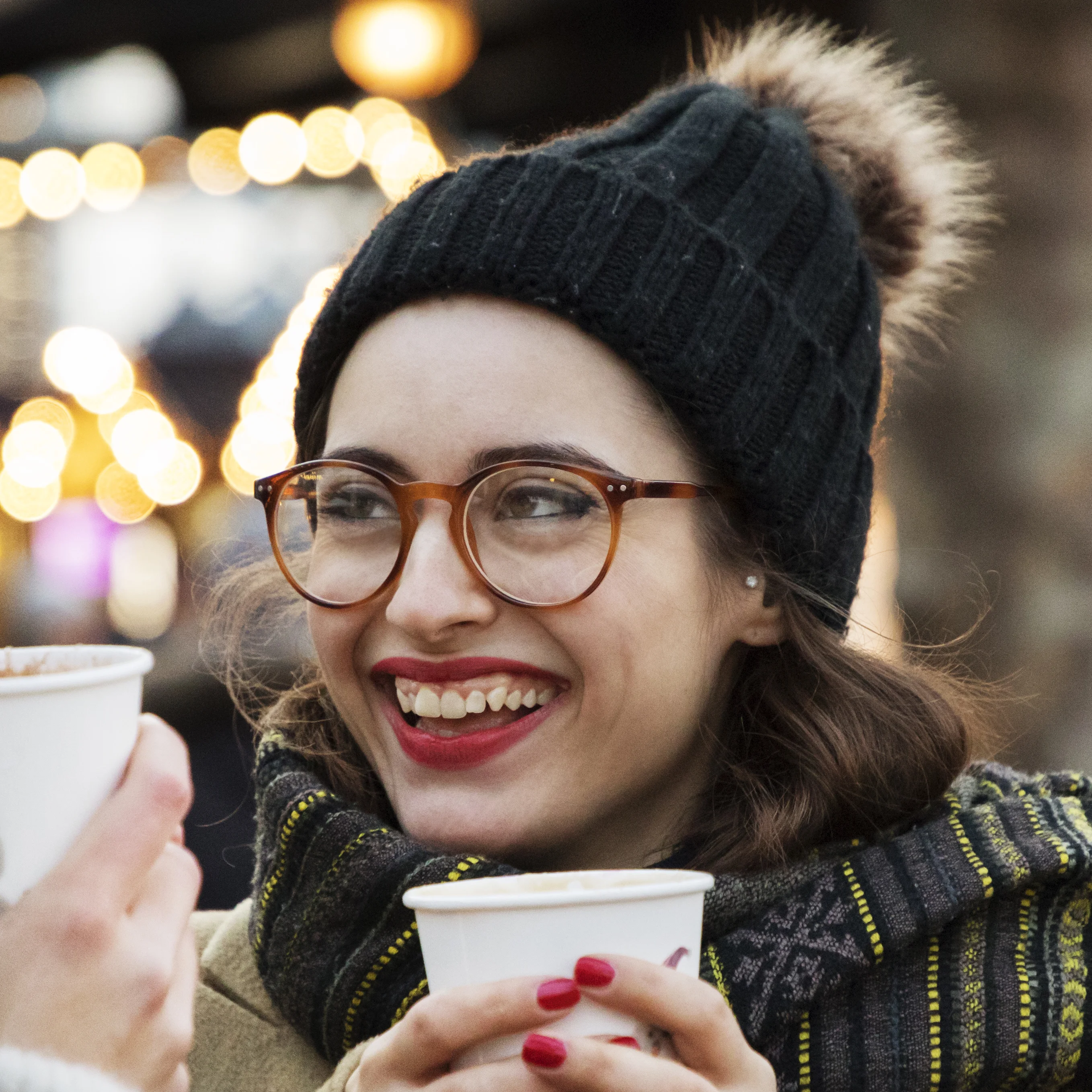 a woman holding a cup and a cell phone