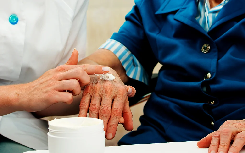 zbliżenie dłoni trzymających biały kubek