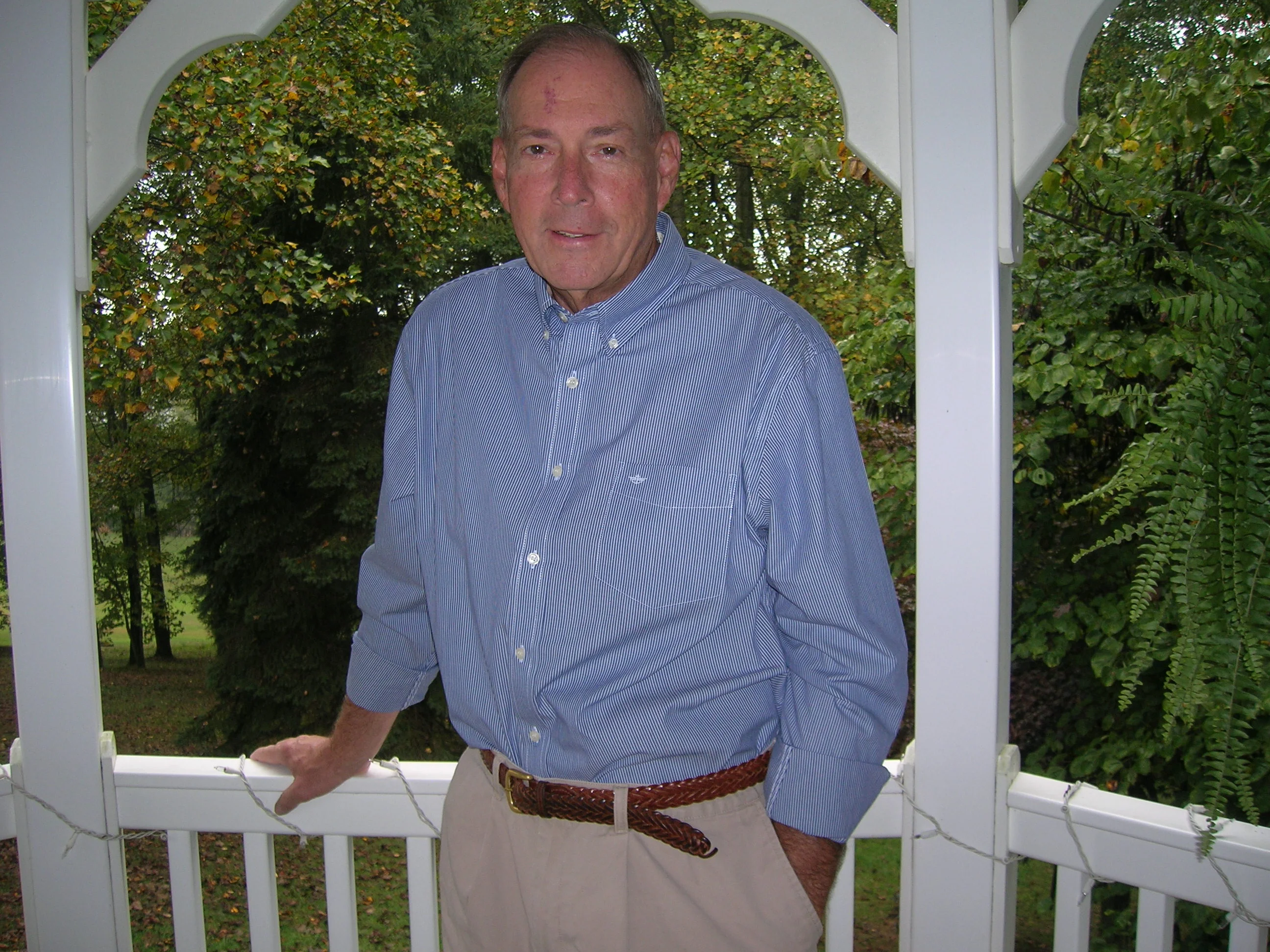 a man standing by a white railing